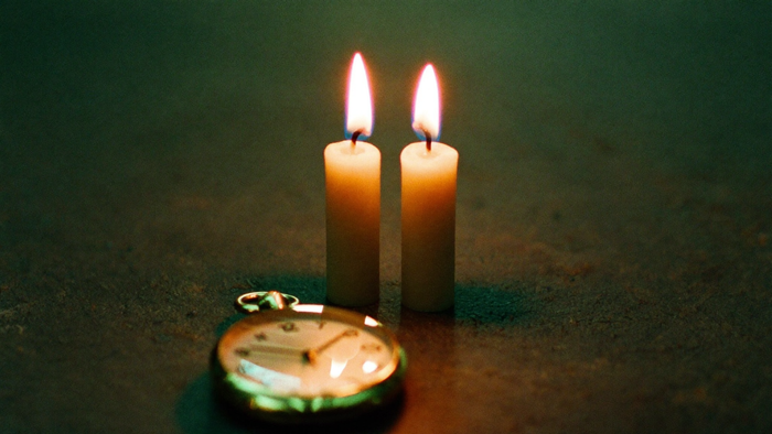 Zwei Kerzen mit Zwillingsflammen und eine Taschenuhr im Kerzenlicht – Spiegelstunde 11:11