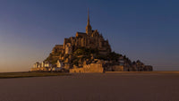 Mont-Saint-Michel in der Abenddämmerung: Gezeiteninsel mit gotischer Abtei und Turmspitze über geriffeltem Watt
