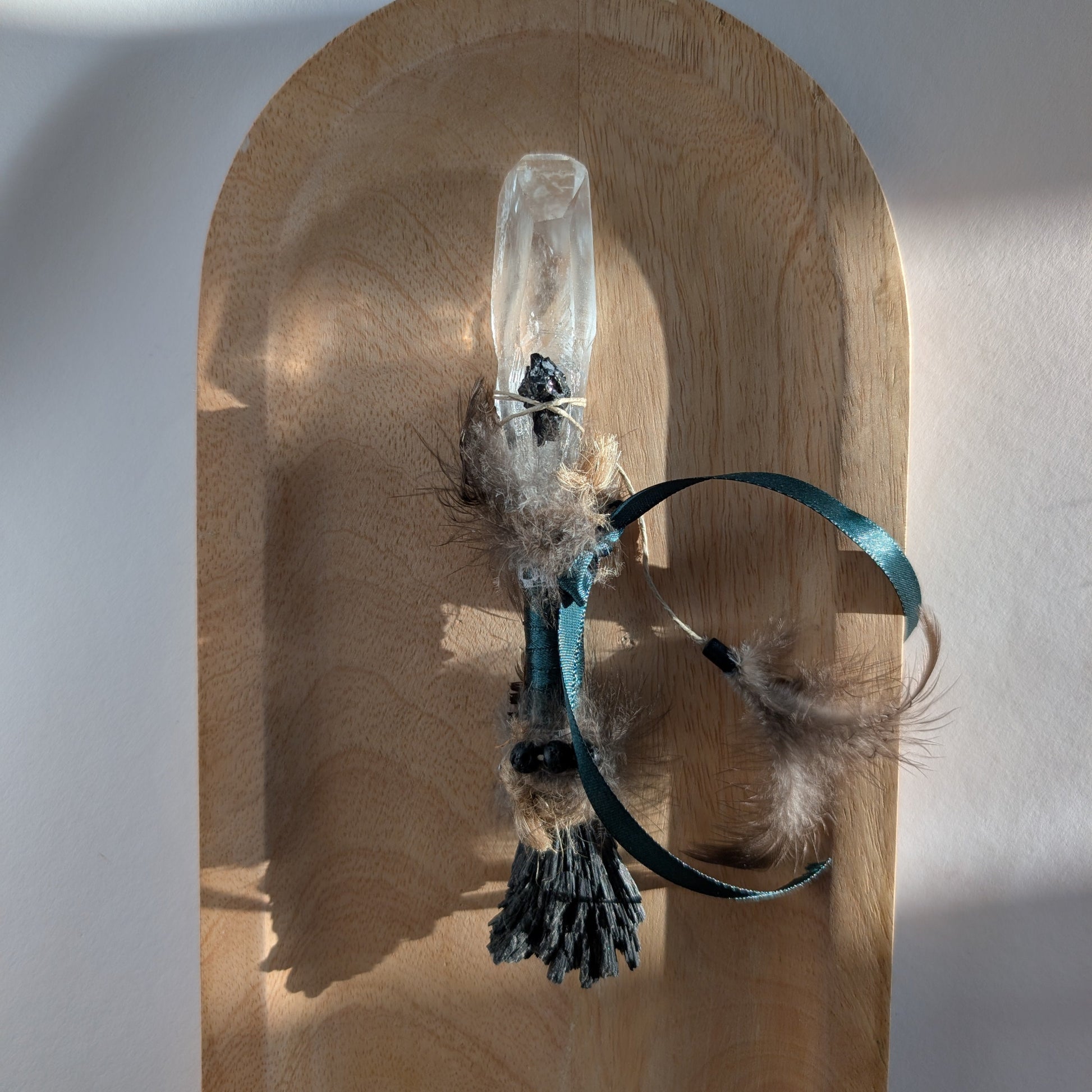 Handgefertigter Zauberstab mit großer Bergkristall-Spitze, verziert mit Federn, Kyanit und einem grünem Band.