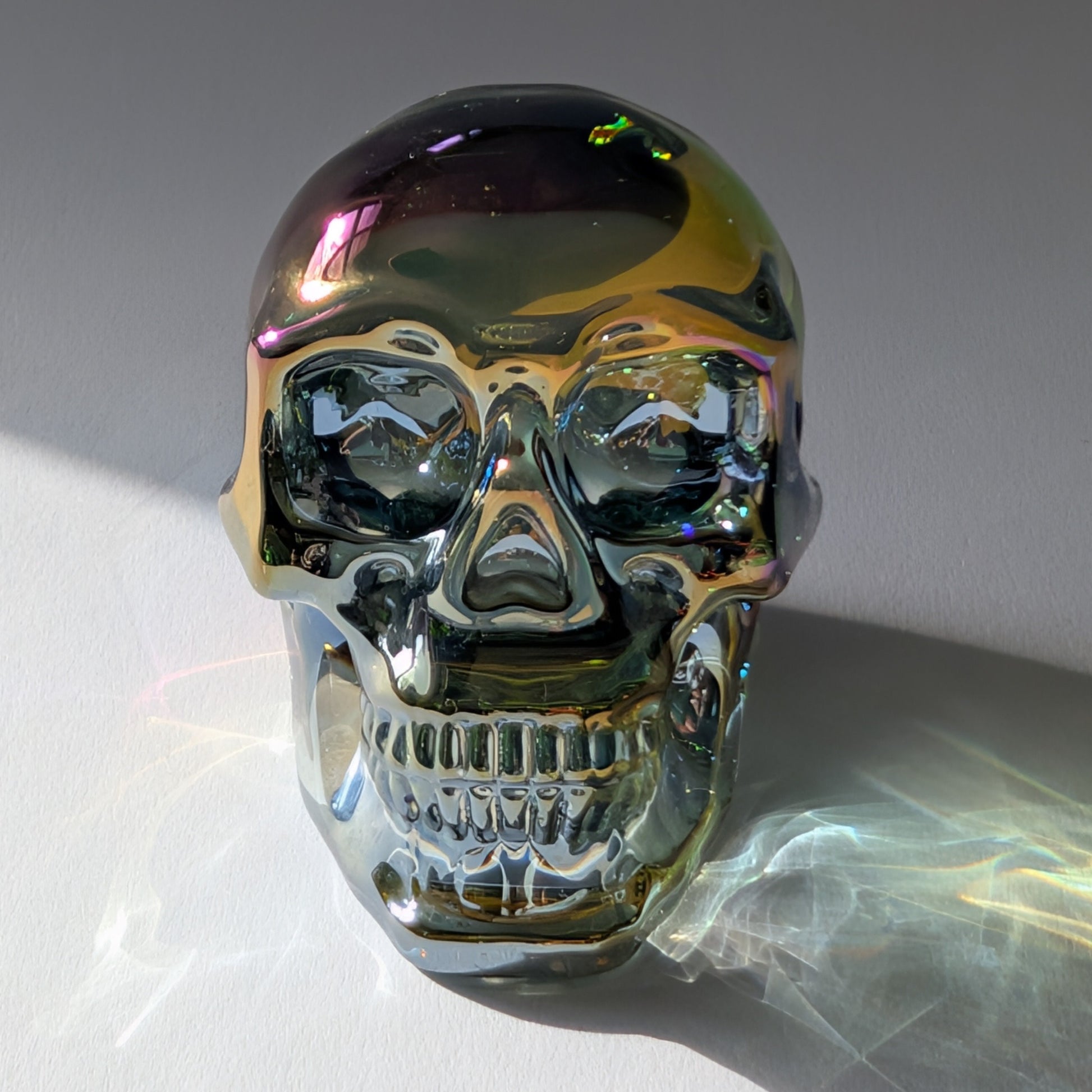 Kristallschädel "Trokan" (298g) aus Quarz mit schillernder Rainbow-Aurora Beschichtung.