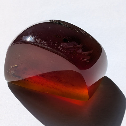Bernstein Unikat "Dämmerlicht" in dunkler, unregelmäßiger Form mit nebelartiger innerer Struktur.