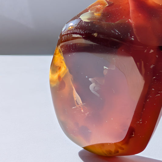 Bernstein Unikat "Die Träne der Sonne" in dunkler, tropfenartiger Form mit rotem Kern.