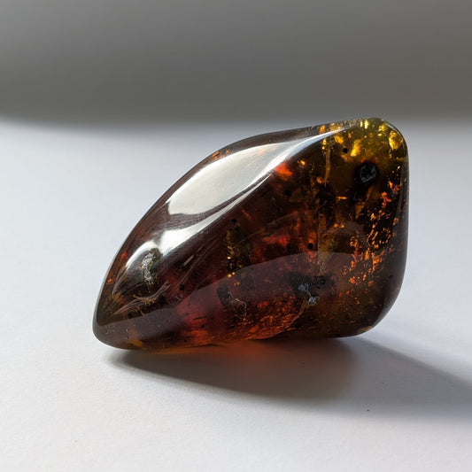 Bernstein Unikat "Waldesnebel" in dunkler, unregelmäßiger Form mit nebelartiger innerer Struktur.