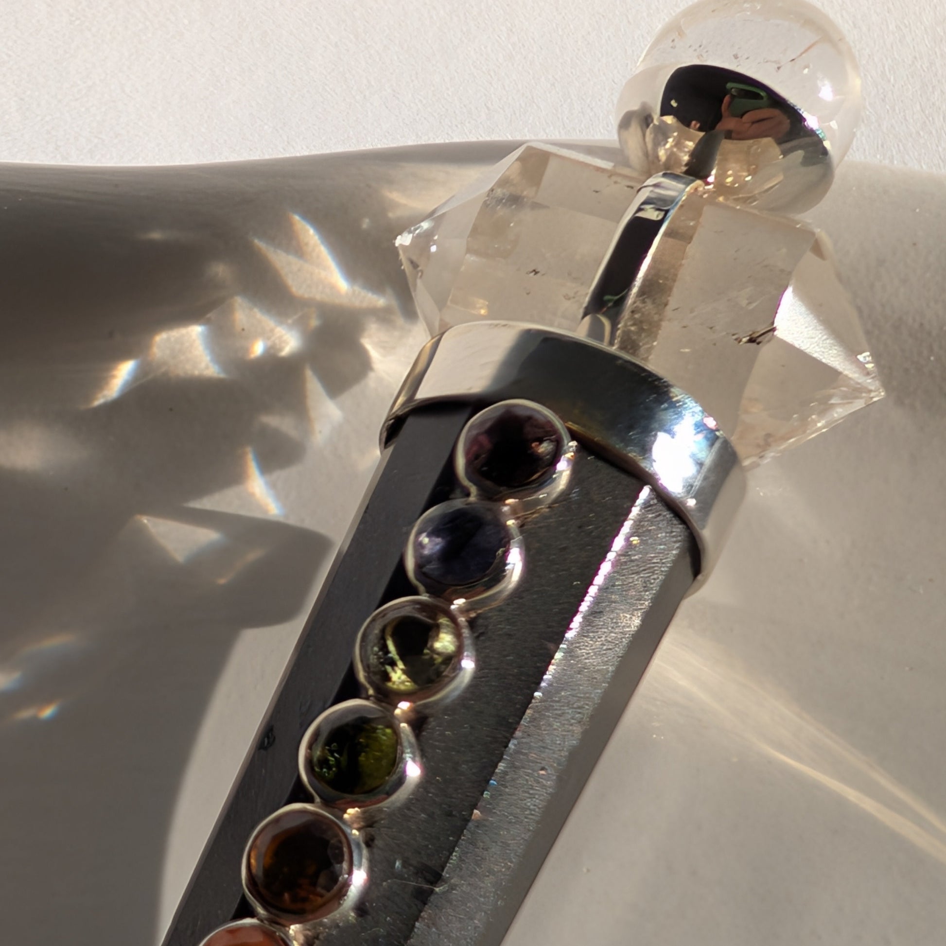 Chakra-Generatorstab aus schwarzem Schungit mit sieben farbigen Steinen und einer Bergkristall-Spitze.