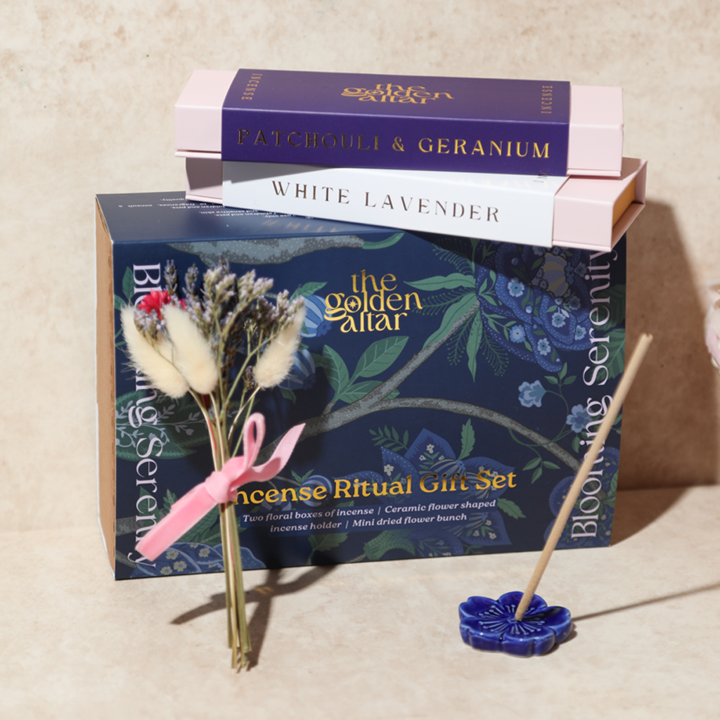 Das Ritual-Set 'Garten der Seele' von The Golden Altar mit zwei Räucherpackungen, einem blumenförmigen Keramikhalter und Trockenblumen in einer blauen Geschenkbox.