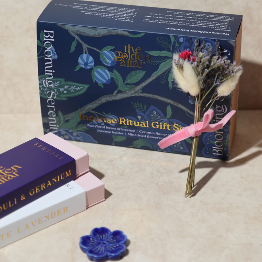 Das Ritual-Set 'Garten der Seele' von The Golden Altar mit zwei Räucherpackungen, einem blumenförmigen Keramikhalter und Trockenblumen in einer blauen Geschenkbox.