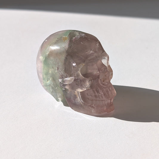 Ein 103g schwerer, handgeschnitzter Kristallschädel 'Uthar' aus durchscheinendem, grün-violettem Regenbogenfluorit.