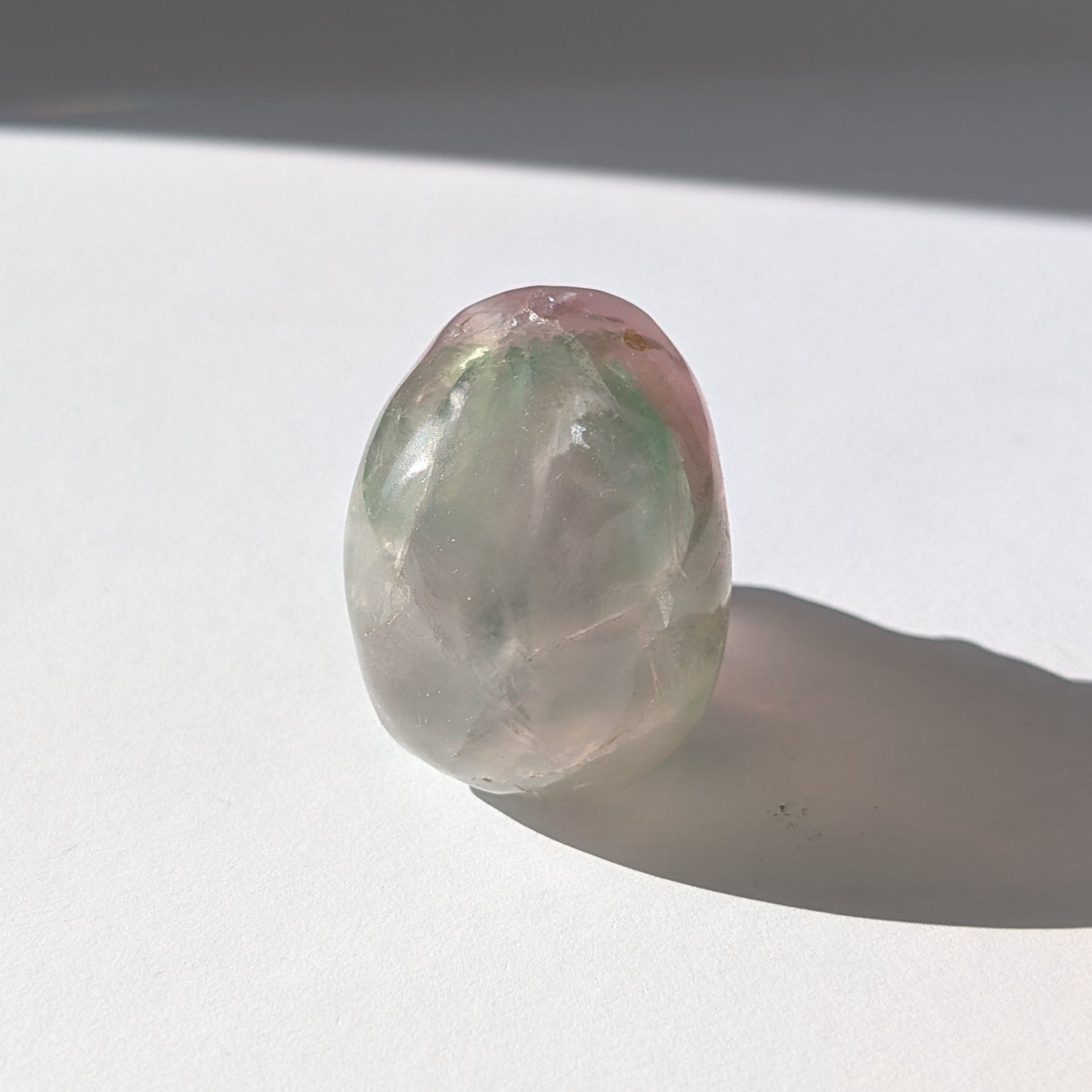 Ein 103g schwerer, handgeschnitzter Kristallschädel 'Uthar' aus durchscheinendem, grün-violettem Regenbogenfluorit.