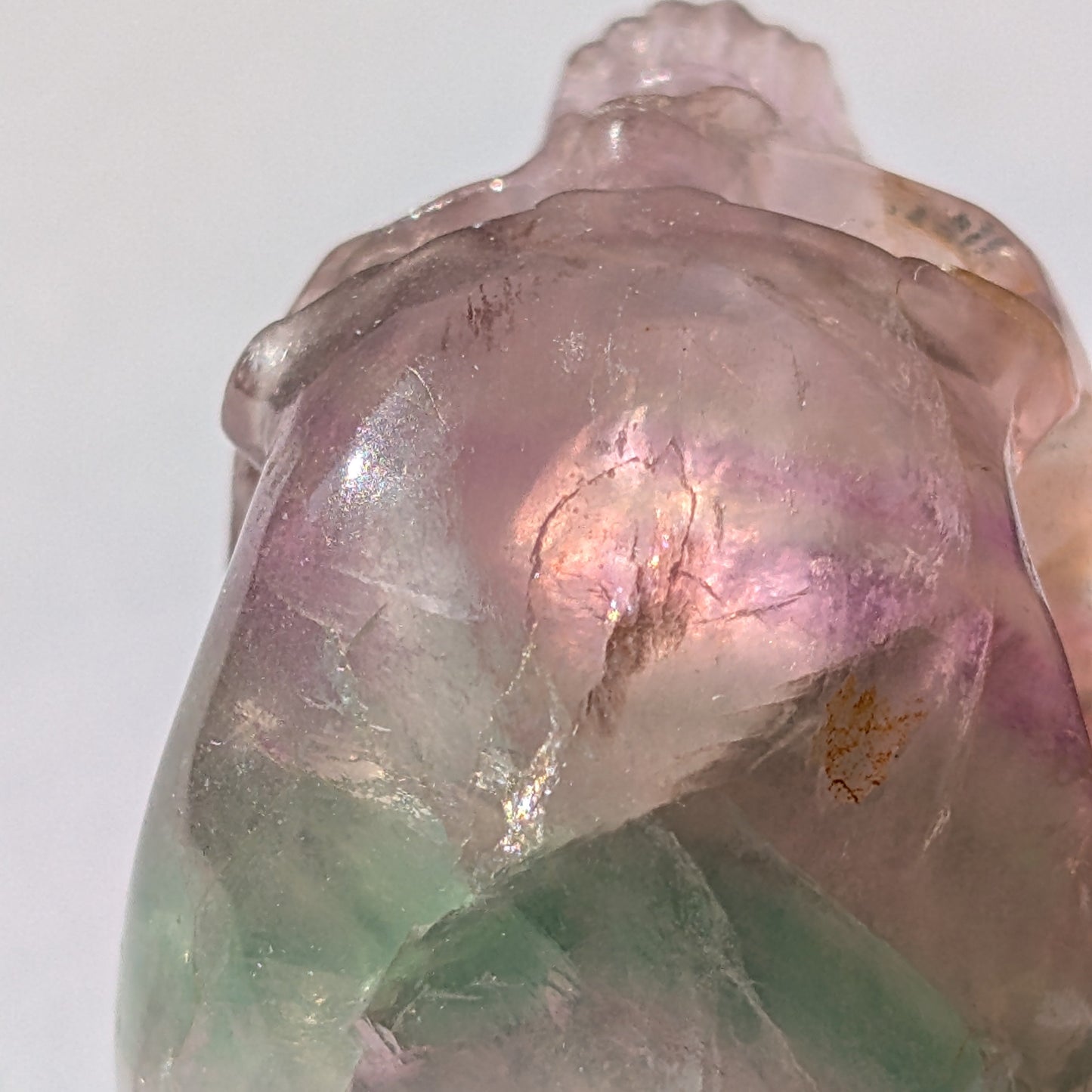 Ein 103g schwerer, handgeschnitzter Kristallschädel 'Uthar' aus durchscheinendem, grün-violettem Regenbogenfluorit.
