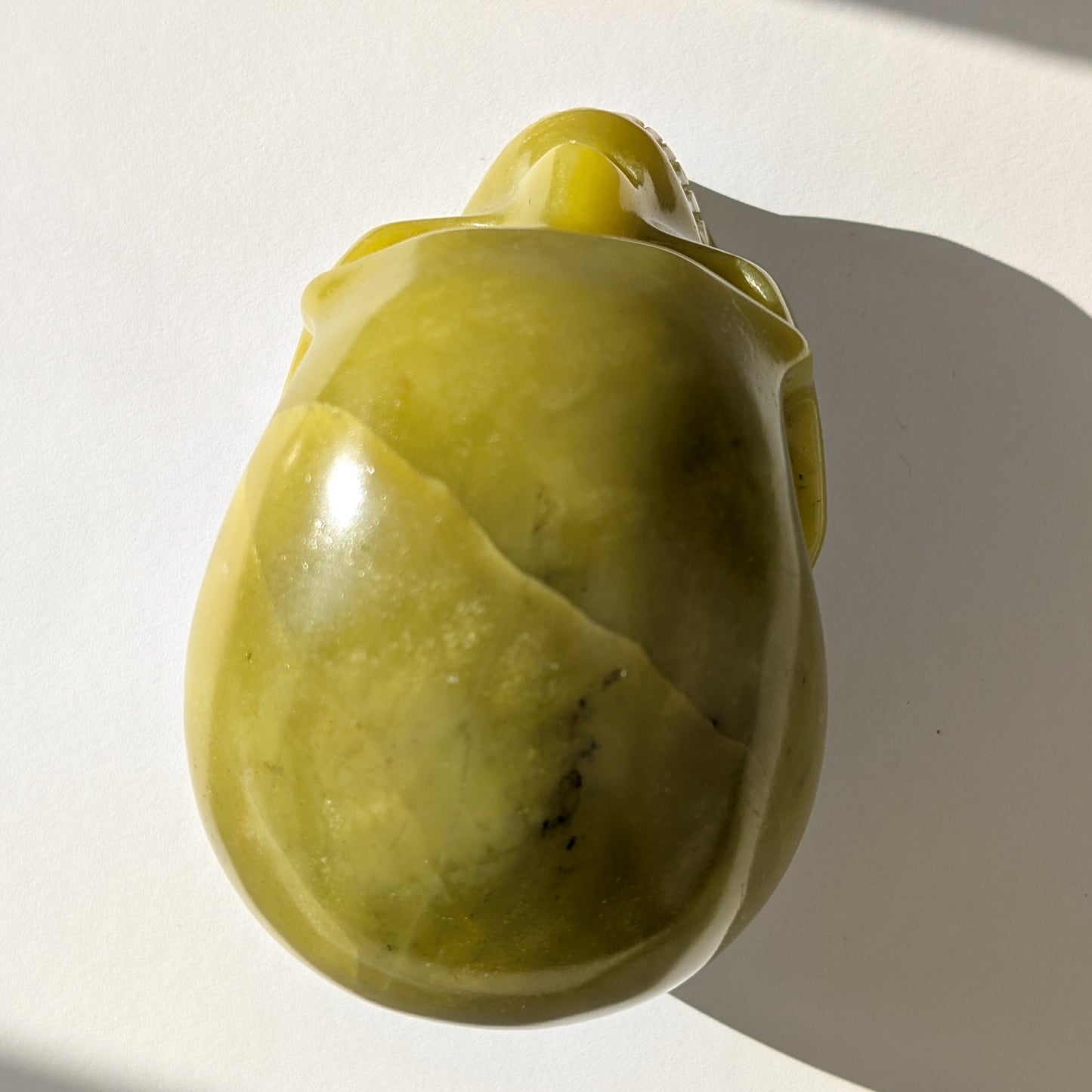 Ein 614g schwerer, handgeschnitzter Kristallschädel 'Jagrimm' aus seidig-grünem Serpentin mit schlangenähnlicher Maserung.