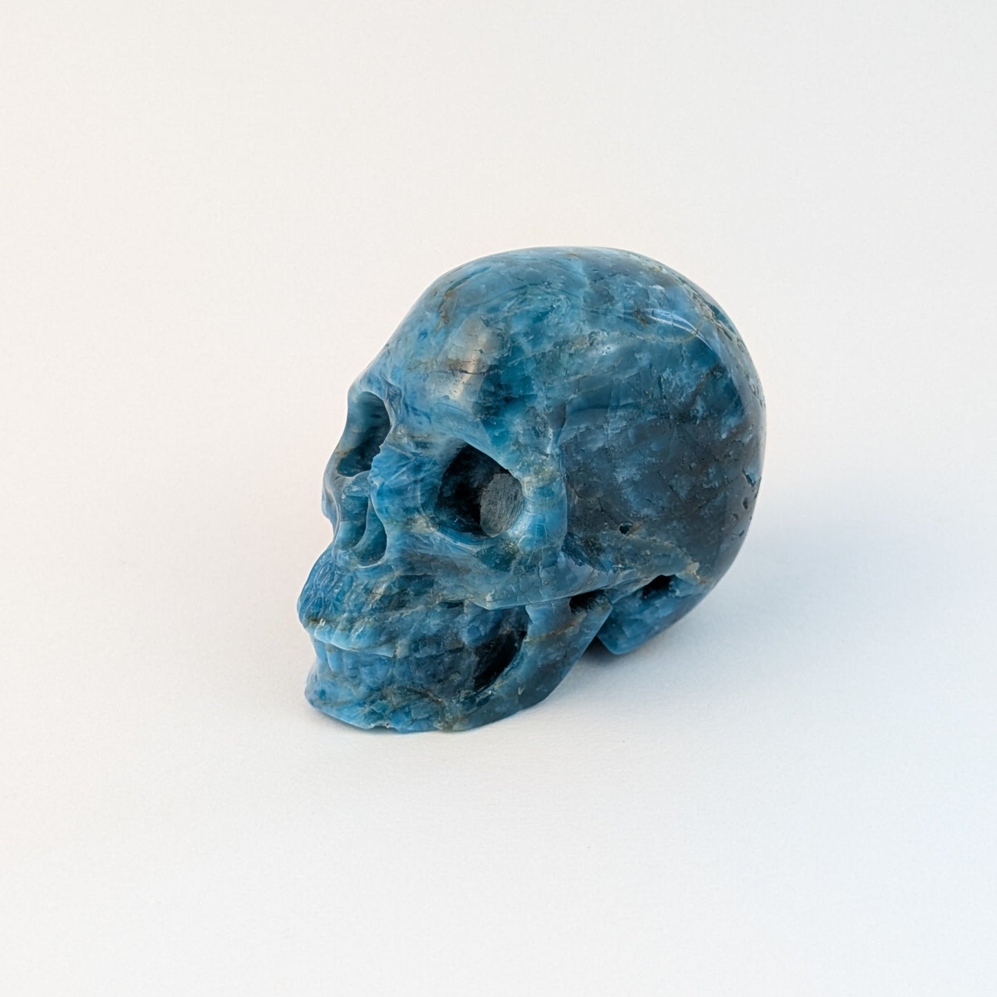 Ein 85g schwerer, handgeschnitzter Kristallschädel 'Sergil' aus leuchtend blau-grünem Apatit, der eine motivierende Energie ausstrahlt.