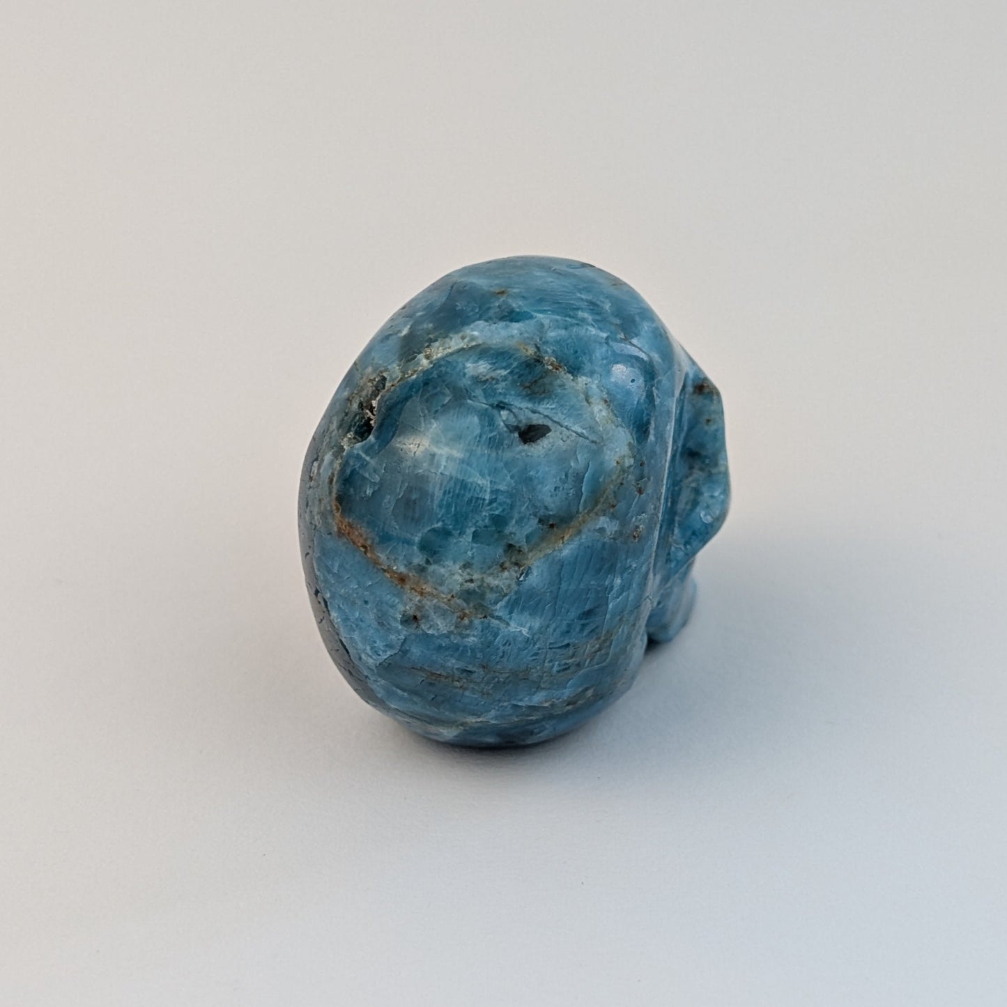 Ein 85g schwerer, handgeschnitzter Kristallschädel 'Sergil' aus leuchtend blau-grünem Apatit, der eine motivierende Energie ausstrahlt.