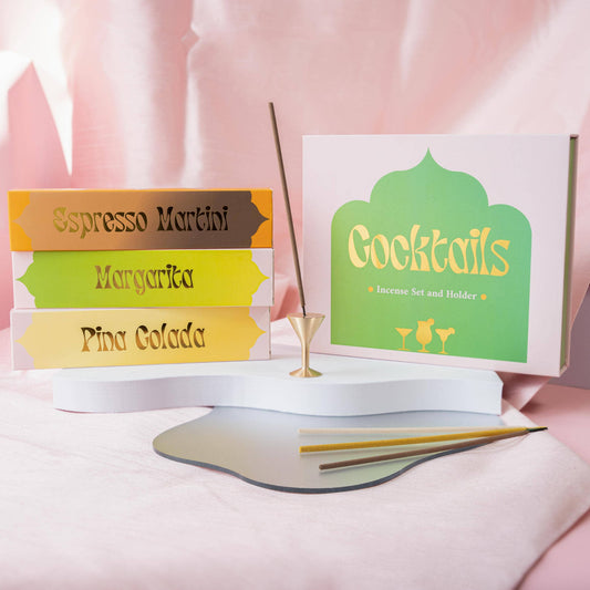 Ein Cocktail-Räucherstäbchen-Geschenkset von The Golden Altar mit drei Duftpackungen (Pina Colada, Espresso Martini, Margarita) und einem goldenen Messinghalter.