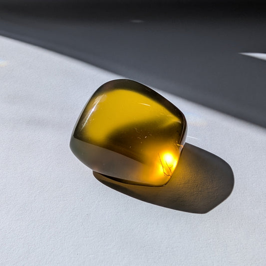 Ein großer, polierter Bicolor-Bernstein 'Der Sonnenstrahl der Vorzeit', der von tiefem Rot-Braun zu einem leuchtenden Sonnengelb übergeht.