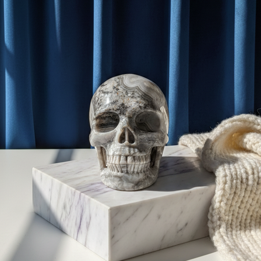 Ein monumentaler, 1352g schwerer Kristallschädel 'Lea' aus Gebändertem Achat mit hypnotischen, fließenden Bändern in Grau-, Schwarz- und Weißtönen.