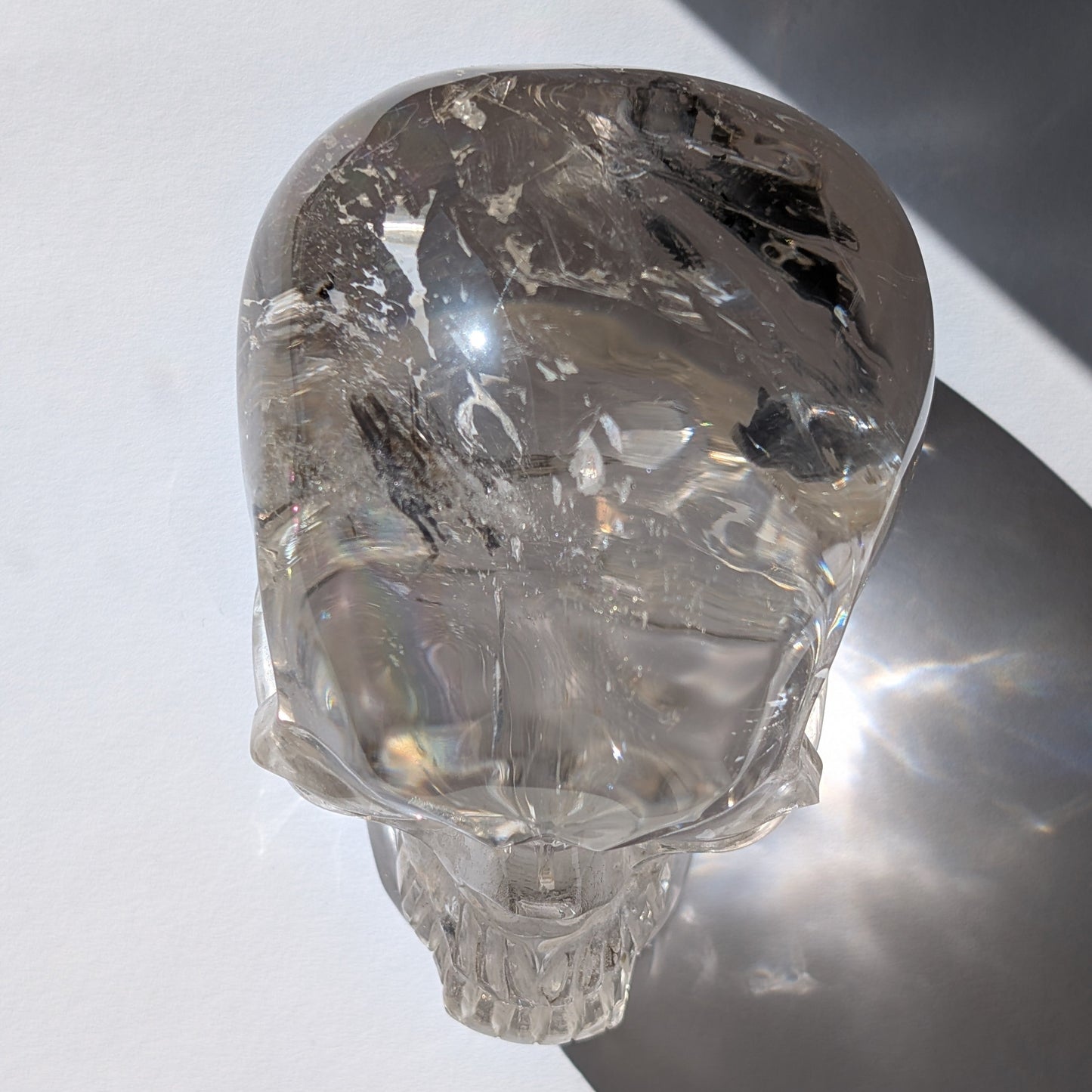 Ein monumentaler, 1450g schwerer Golden Healer Bergkristall-Schädel 'Der Lichtbringer' mit unzähligen leuchtenden Regenbogen-Einschlüssen.