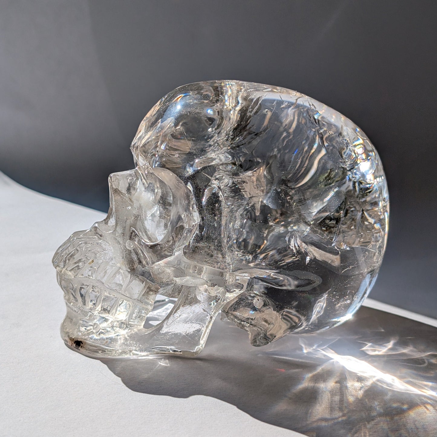 Ein monumentaler, 1450g schwerer Golden Healer Bergkristall-Schädel 'Der Lichtbringer' mit unzähligen leuchtenden Regenbogen-Einschlüssen.