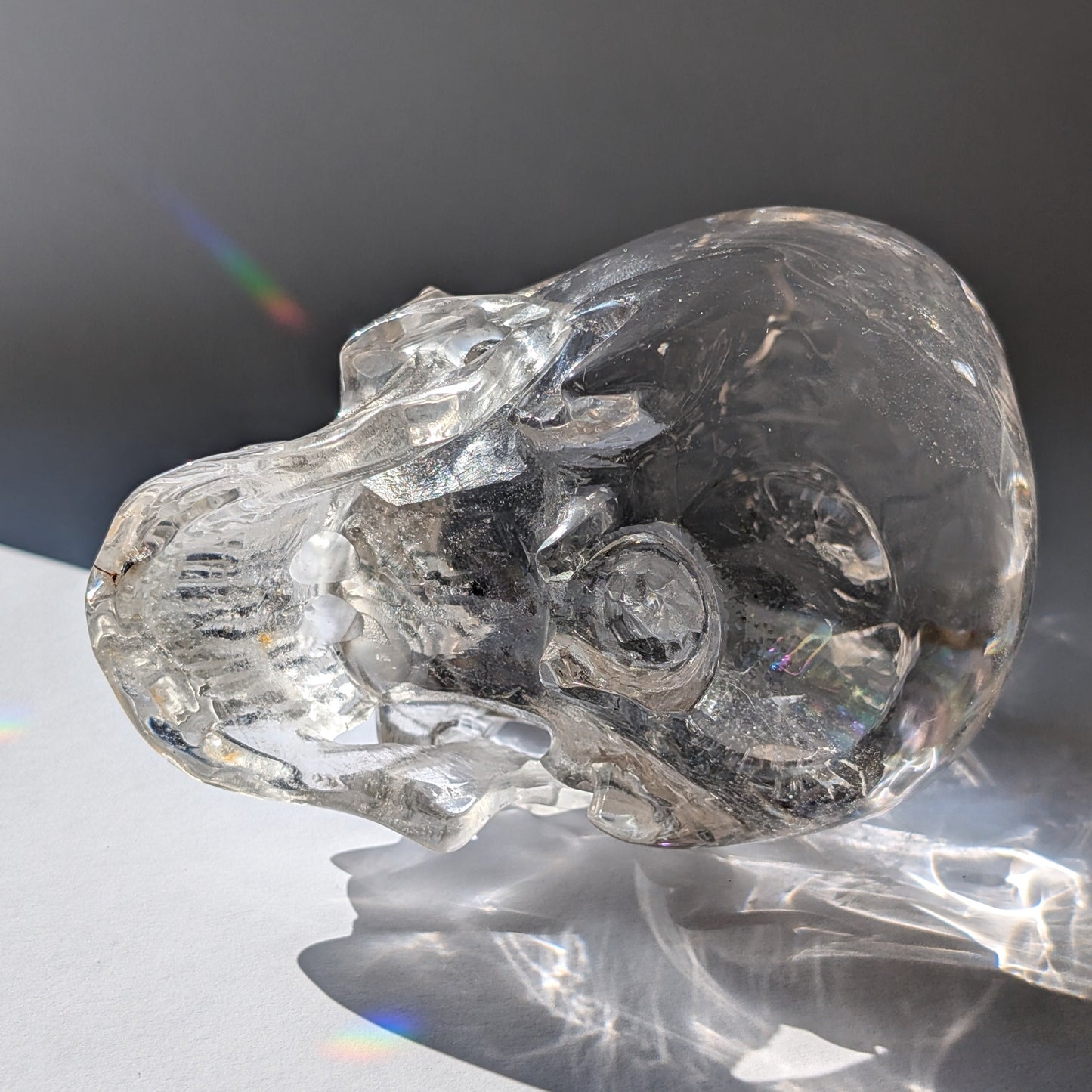 Ein monumentaler, 1450g schwerer Golden Healer Bergkristall-Schädel 'Der Lichtbringer' mit unzähligen leuchtenden Regenbogen-Einschlüssen.