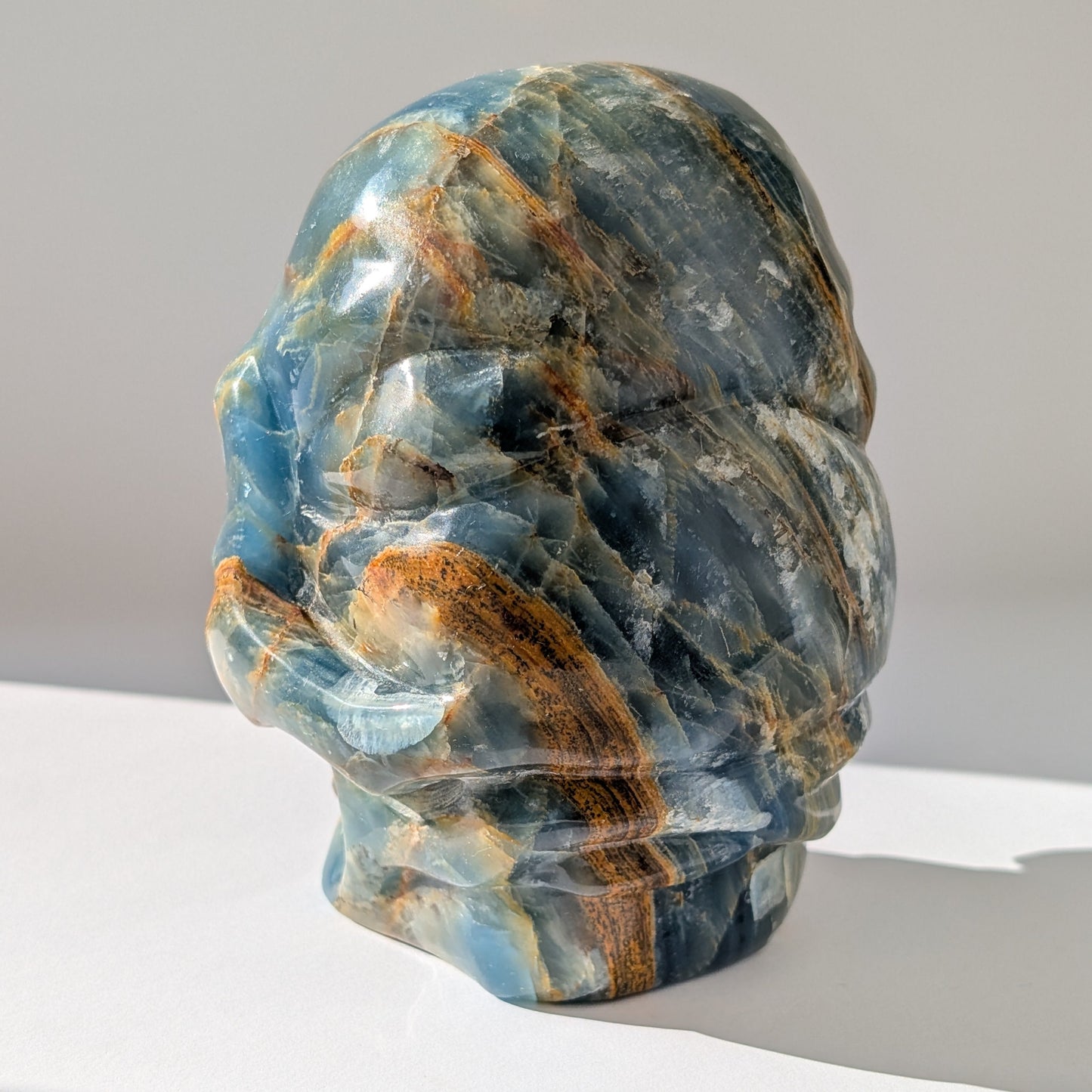 Ein monumentaler, 1654g schwerer Kristallschädel 'Istari' aus ozeanblauem Onyx mit erdigen Bändern, als Teil einer limitierten, auf Bali gefertigten Meister-Edition.