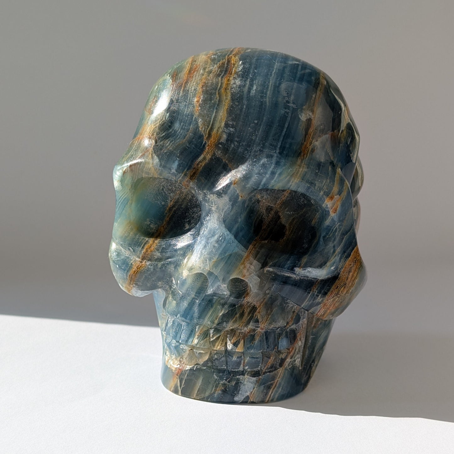 Ein monumentaler, 1654g schwerer Kristallschädel 'Istari' aus ozeanblauem Onyx mit erdigen Bändern, als Teil einer limitierten, auf Bali gefertigten Meister-Edition.