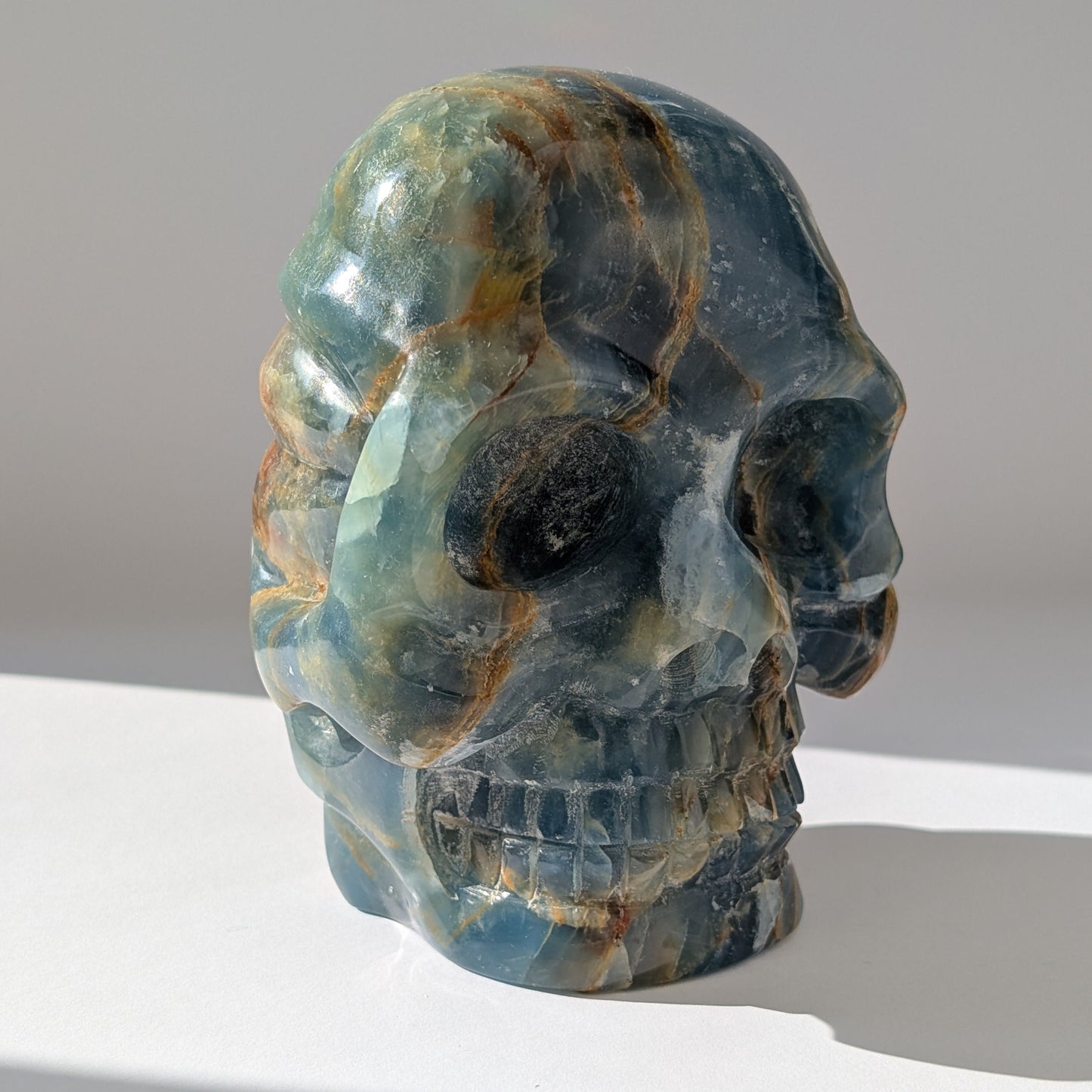 Ein monumentaler, 1654g schwerer Kristallschädel 'Istari' aus ozeanblauem Onyx mit erdigen Bändern, als Teil einer limitierten, auf Bali gefertigten Meister-Edition.
