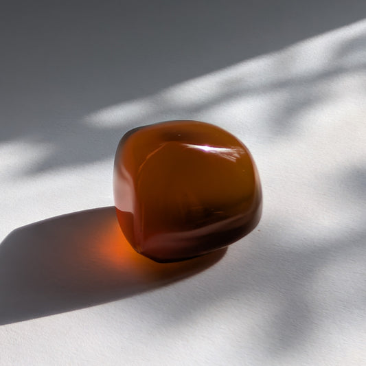 Eleganter Bicolor-Bernstein 'Der Seelenwärmer' in natürlicher Freiform, der sanft von tiefem Rot in einen goldenen Cognac-Ton übergeht.