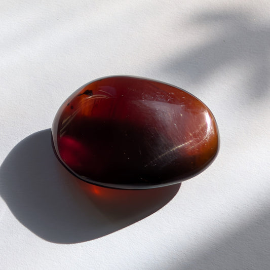 Eleganter Bicolor-Bernstein 'Herz der Dämmerung' in natürlicher Freiform, der sanft von tiefem Rot in einen goldenen Cognac-Ton übergeht.