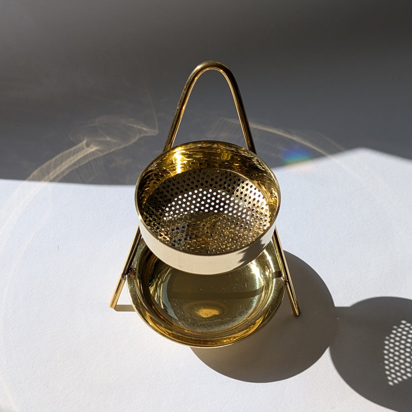 Elegantes, goldenes Räucherstövchen 'Altar der Transformation' aus Messing mit Sieb auf weißem Grund.
