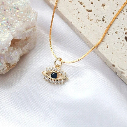 Goldene Evil Eye Halskette mit blauen und farblosen Zirkonia.