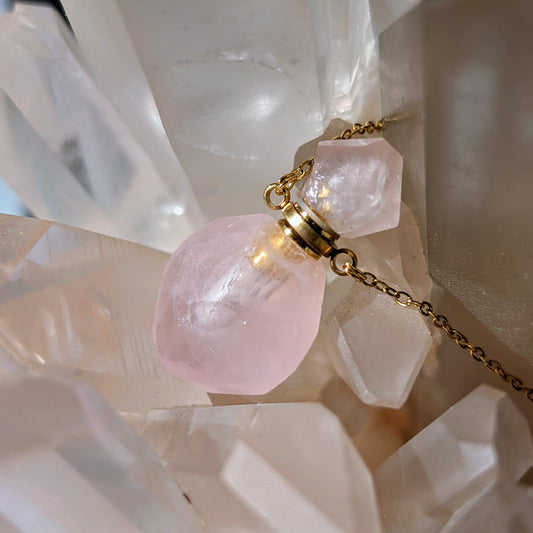 Goldene Flaschenhalskette mit einem Anhänger aus zartrosa Rosenquarz-Heilkristall.