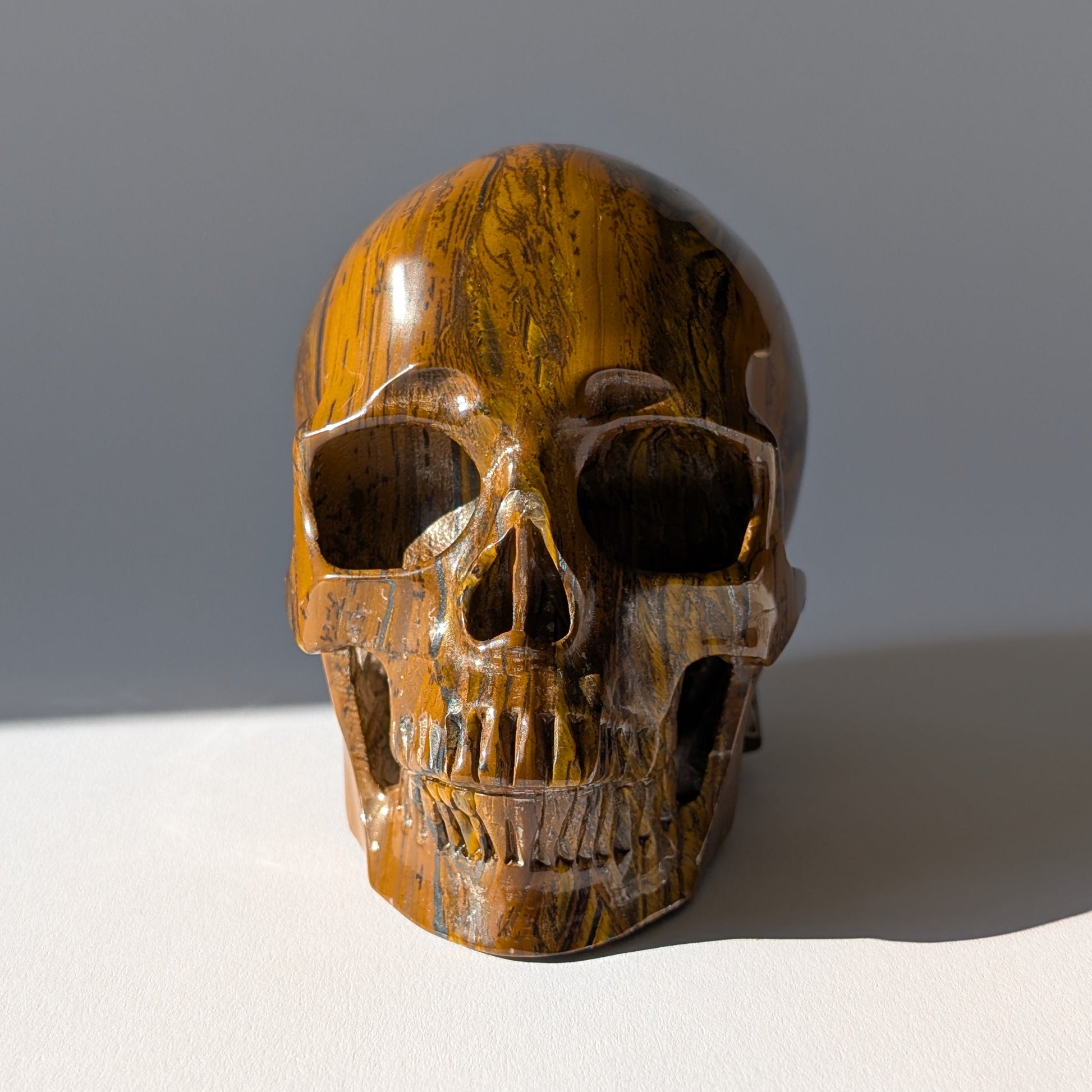 Großer Kristallschädel "Mekil" (1.32kg) aus gebändertem Tigereisen mit Goldschimmer.