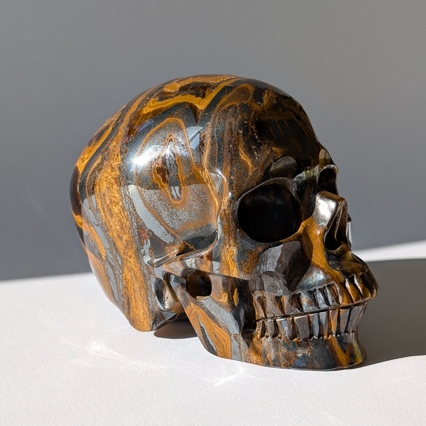 Großer Kristallschädel "Roban" (1.55kg) aus hochwertigem Tigereisen mit starkem Goldschimmer.