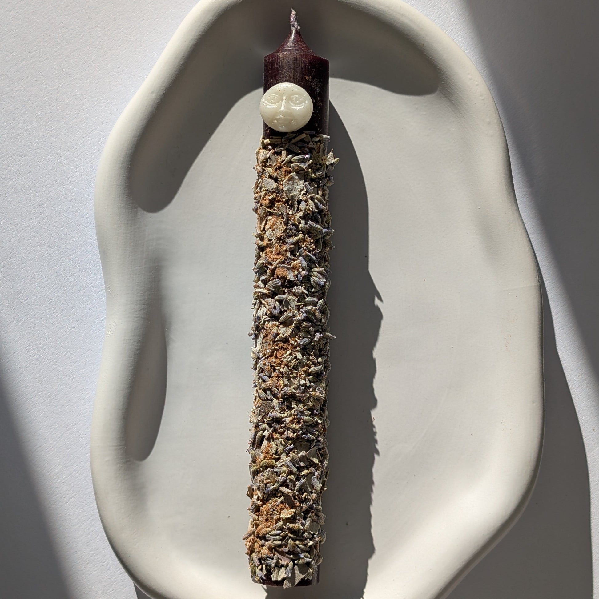 Handgegossene Vollmond Ritualkerze "Lunar Abundance" mit Kräutern in einem Glasgefäß.