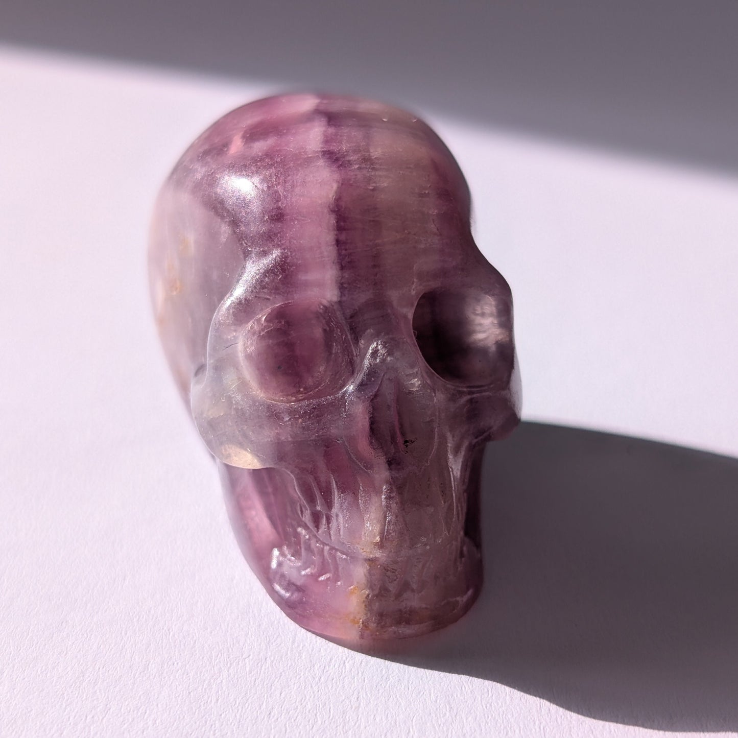 Kleiner Kristallschädel "Boron" (99g) aus klar gebändertem violett-weißem Fluorit.