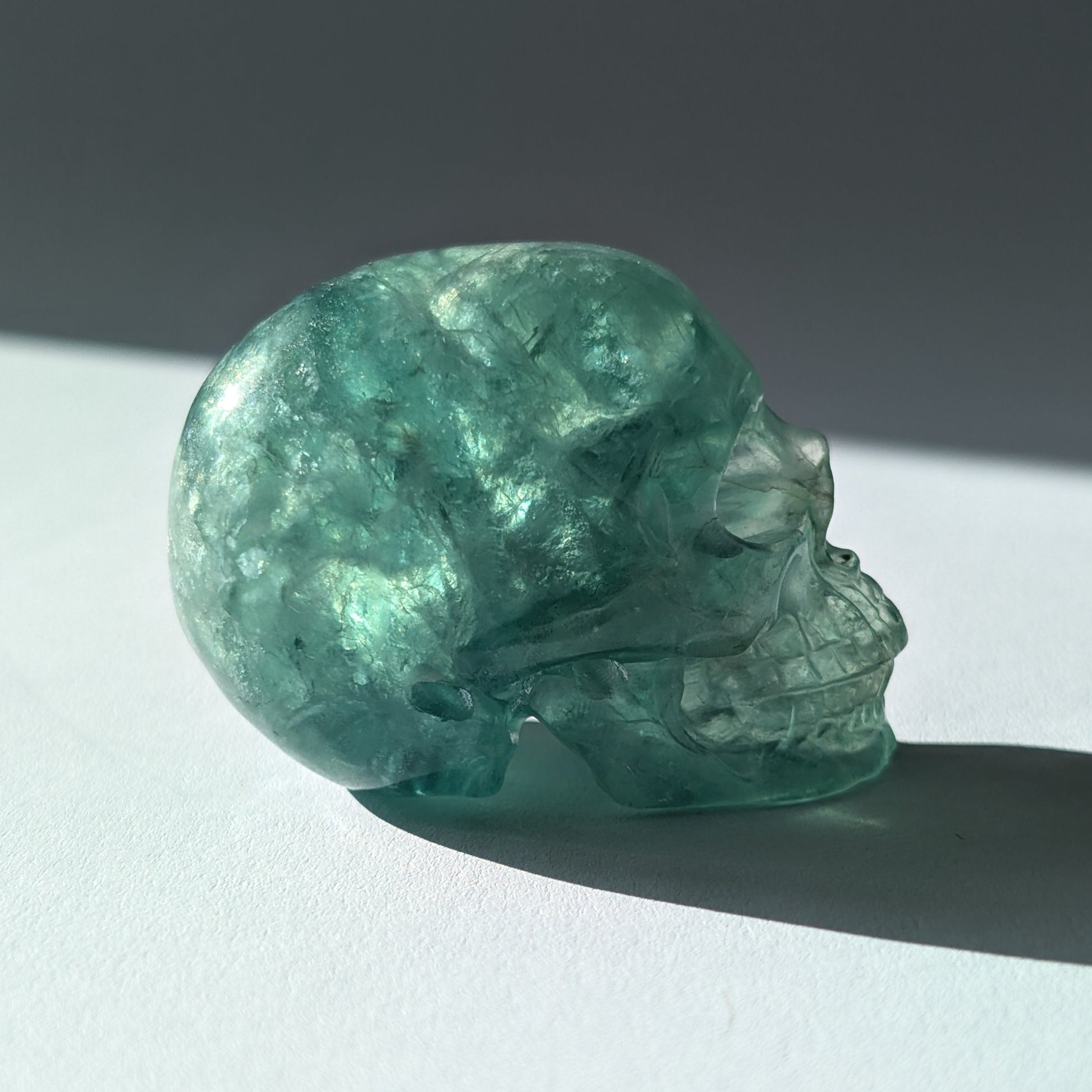 Kleiner Kristallschädel "Buros" (98g) aus klar gebändertem violett-weißem Fluorit.