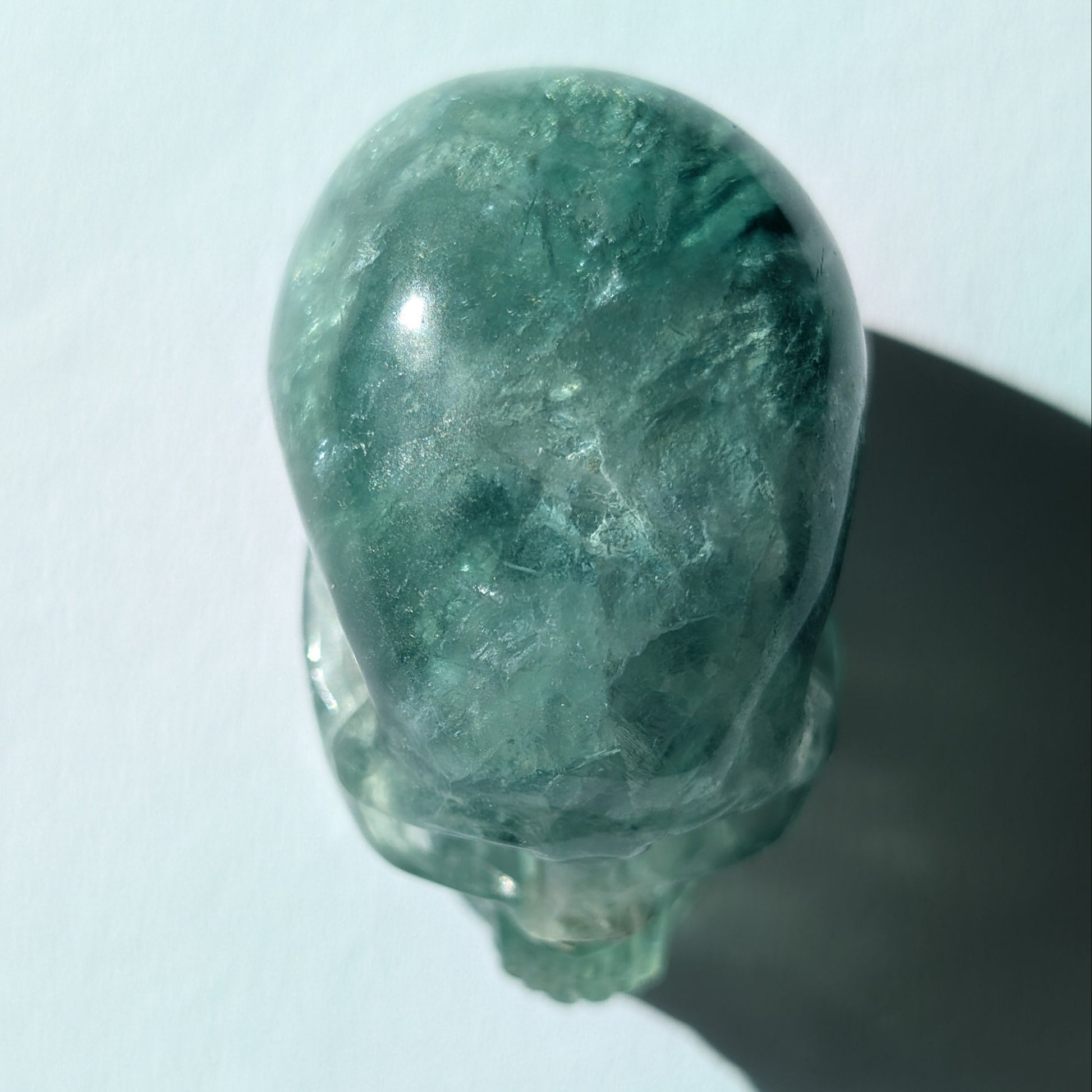 Kleiner Kristallschädel "Buros" (98g) aus klar gebändertem violett-weißem Fluorit.