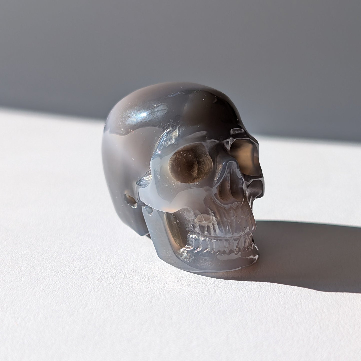 Kleiner Kristallschädel "Colan" (85g) aus grau-weiß gebändertem Botswana Achat.