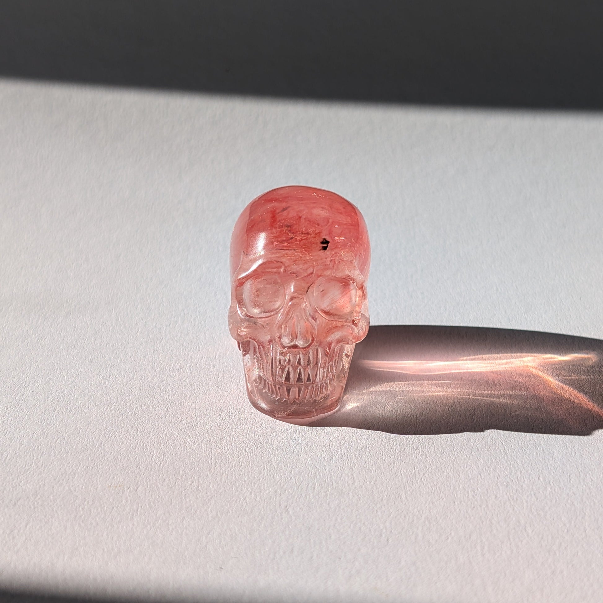 Kleiner Kristallschädel "Elder" (70g) aus leuchtend rosa-rotem Kirschquarz.