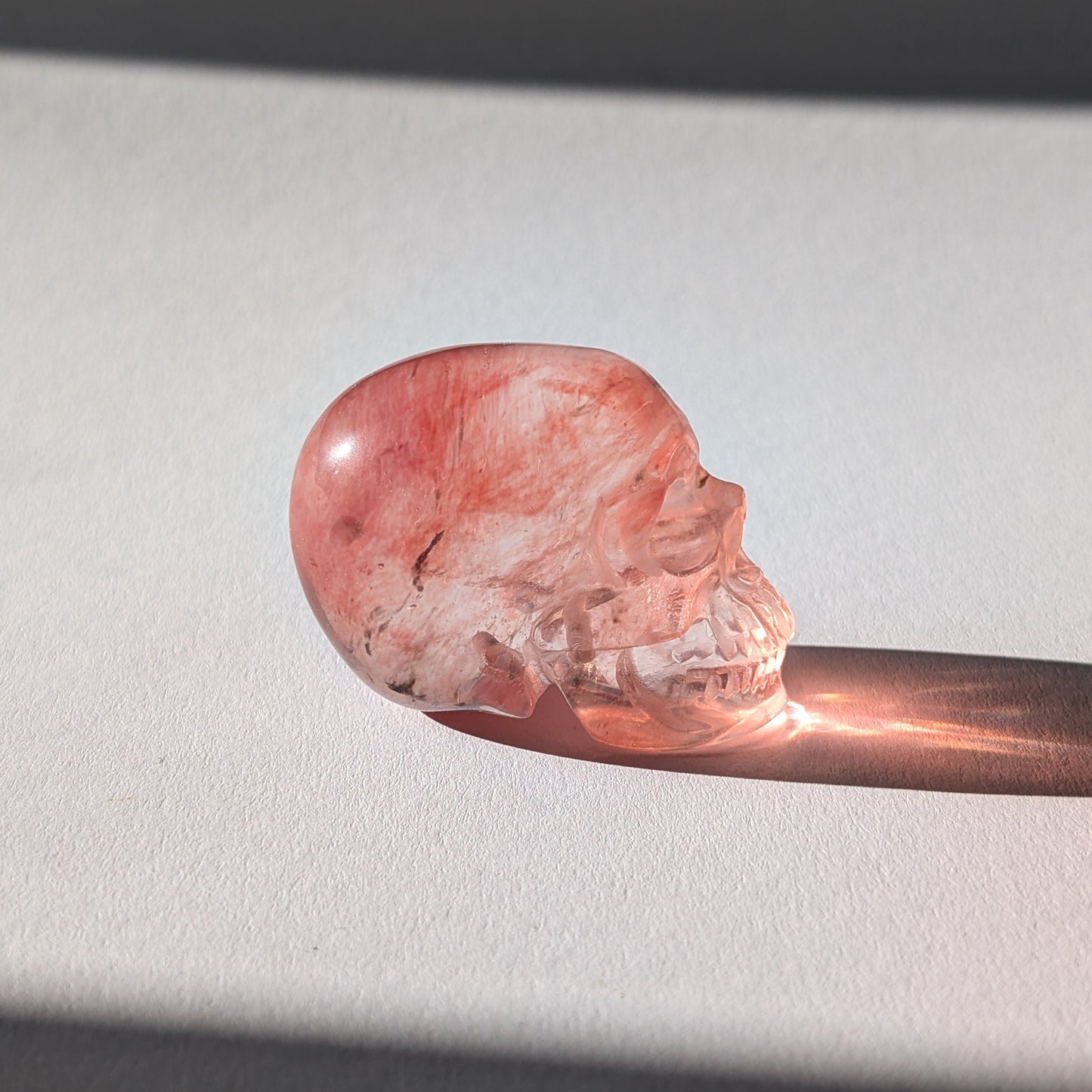 Kleiner Kristallschädel "Elder" (70g) aus leuchtend rosa-rotem Kirschquarz.