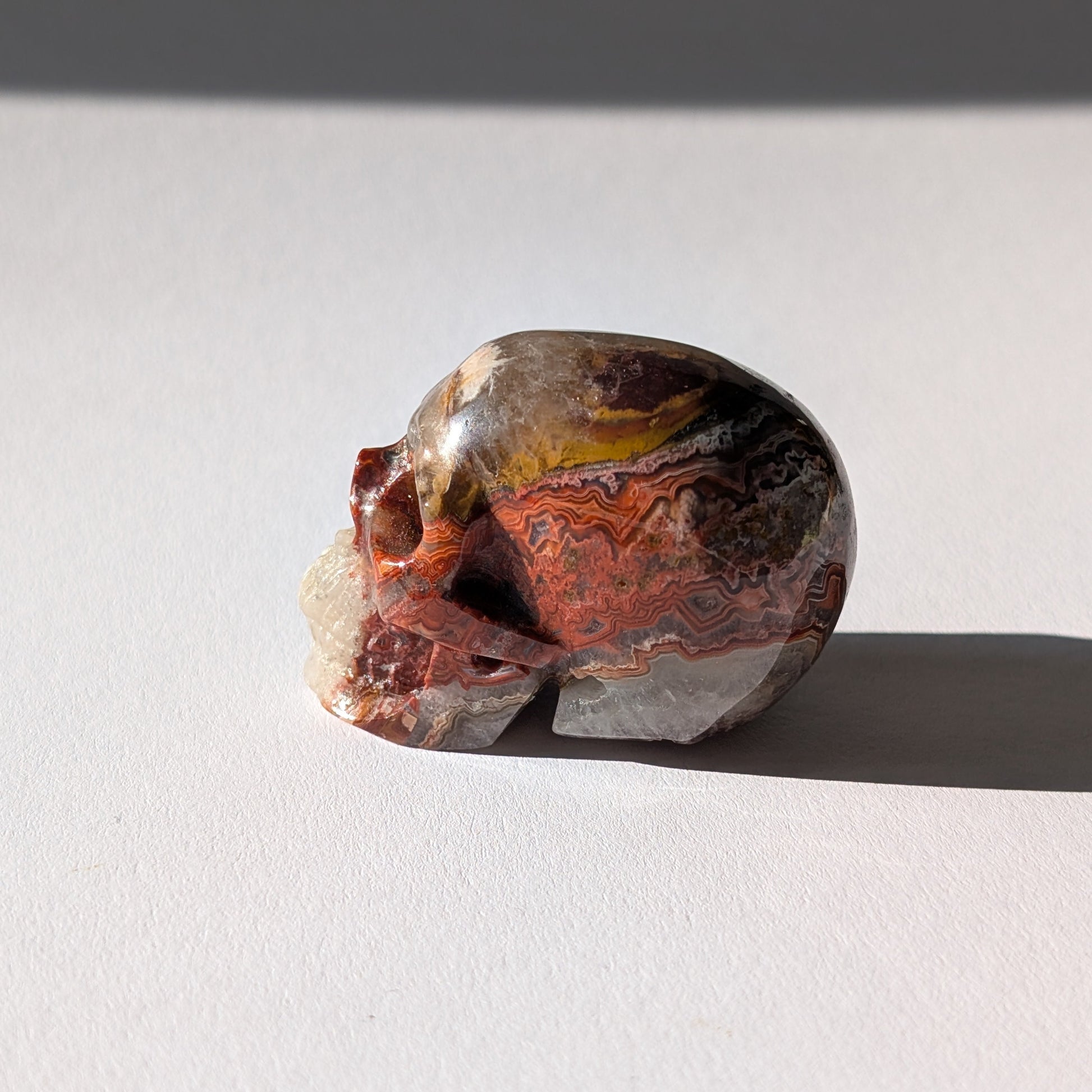 Kleiner Kristallschädel "Marjaana" (79g) aus bunt gebändertem Crazy Lace Achat.