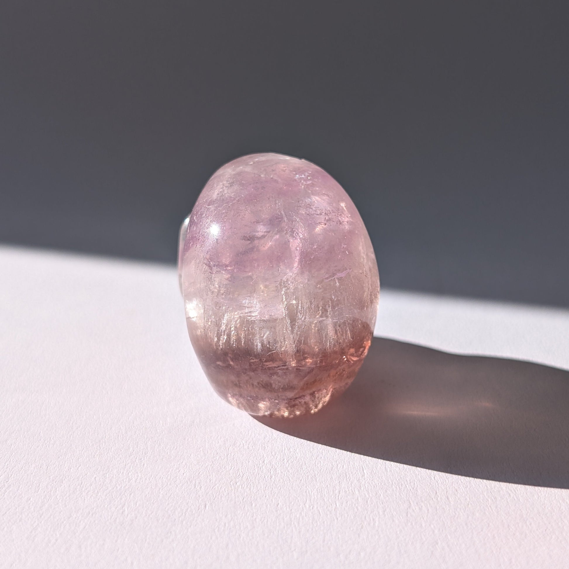 Kleiner Kristallschädel "Nilas" (87g) aus zart rosa-violettem Fluorit im Licht.