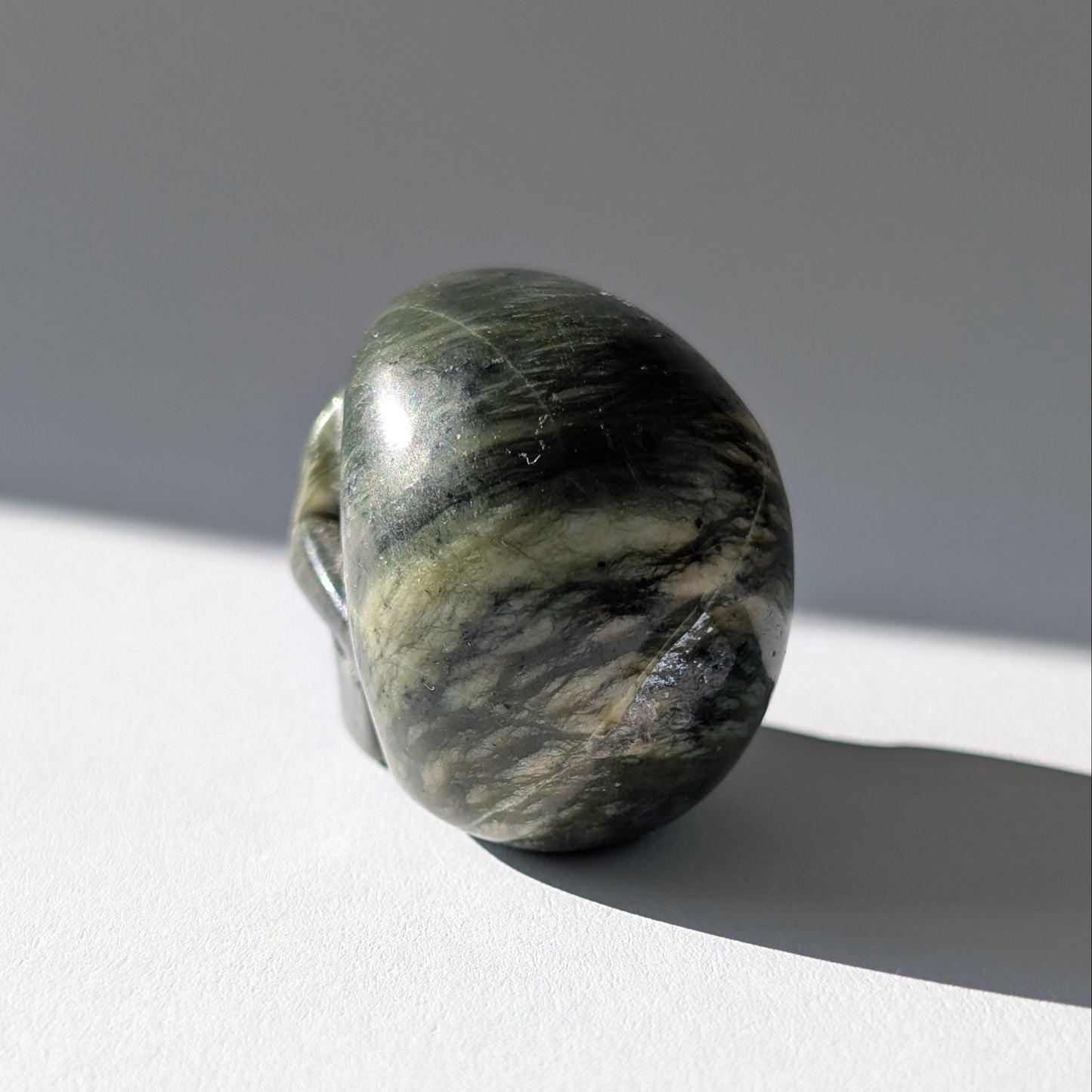 Kleiner Kristallschädel "Obak" (78g) aus dunkelgrün gemustertem Serpentin.