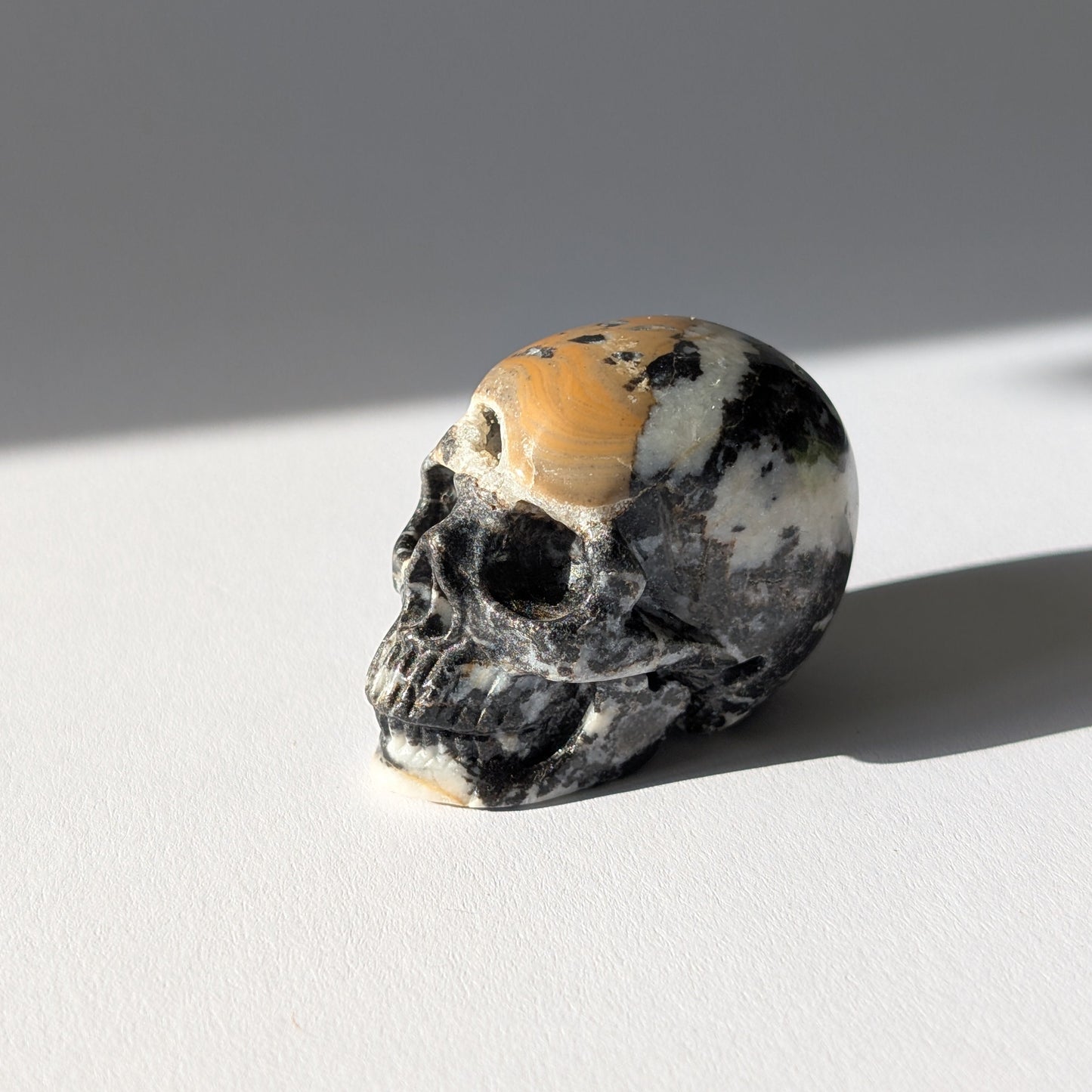 Kleiner Kristallschädel "Peasant" (88g) aus gemustertem Kalkstein (Picasso-Stein Optik).