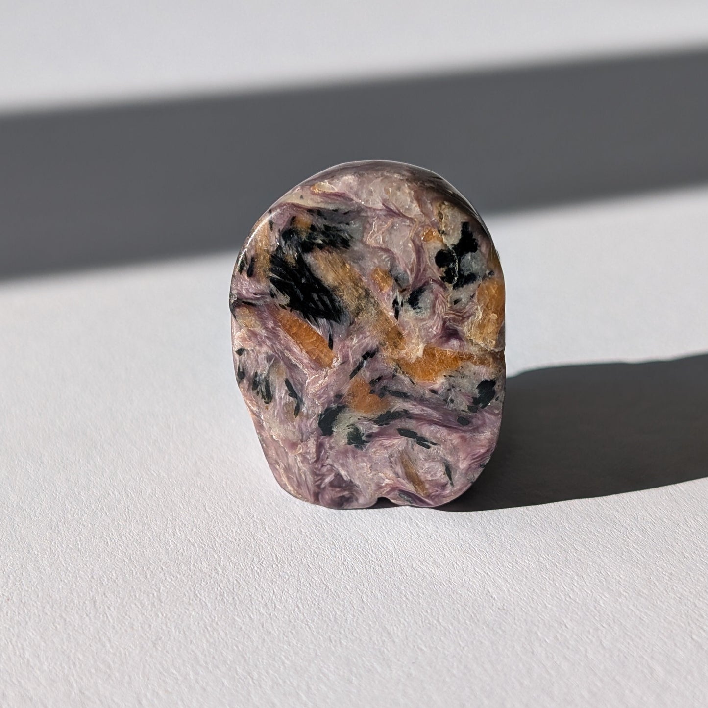 Kleiner Kristallschädel "Veykor" (51g) aus violettem Charoit mit seidigen Wirbeln.