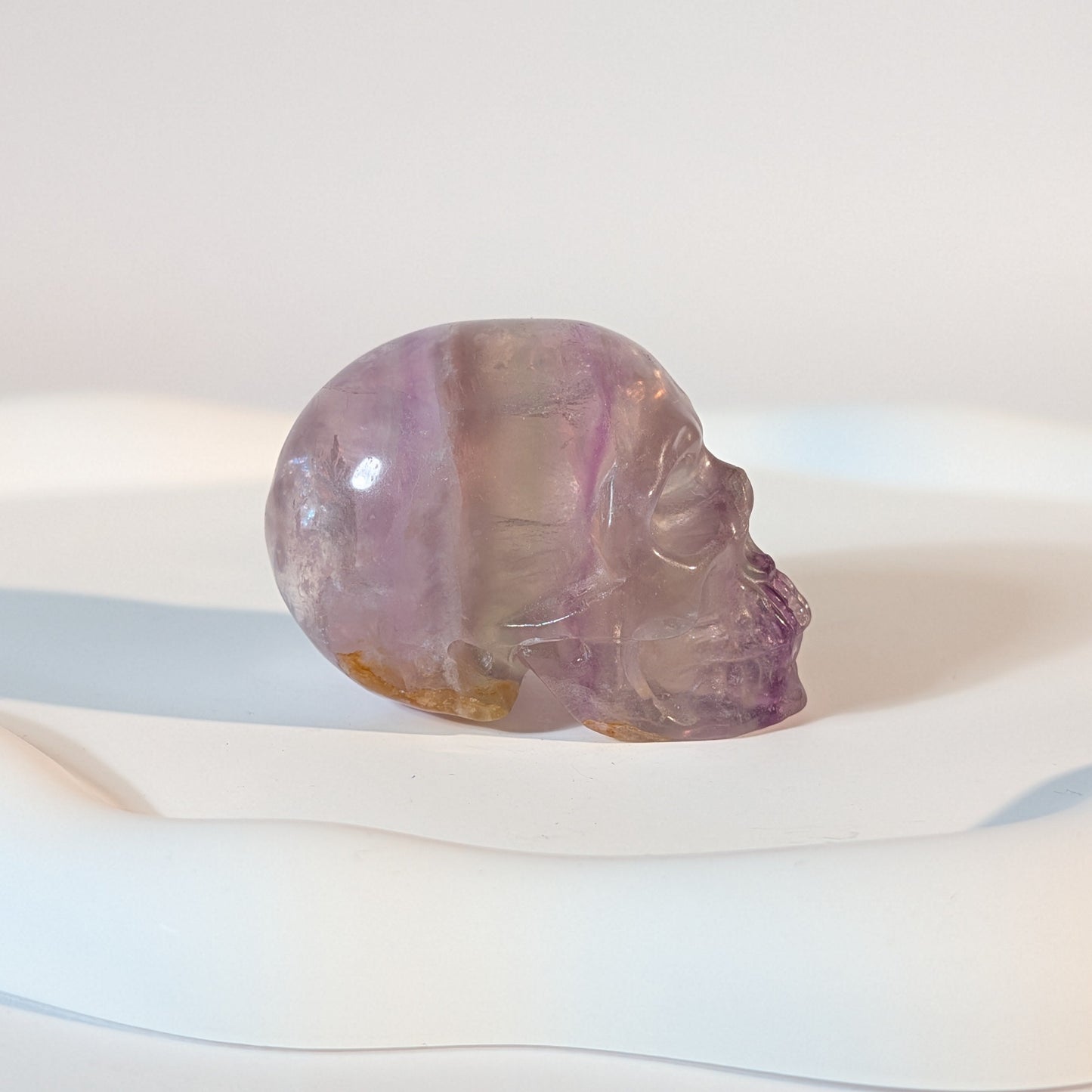 Kompakter Kristallschädel Teitur aus durchscheinendem, violettem Fluorit mit sanften inneren Strukturen.