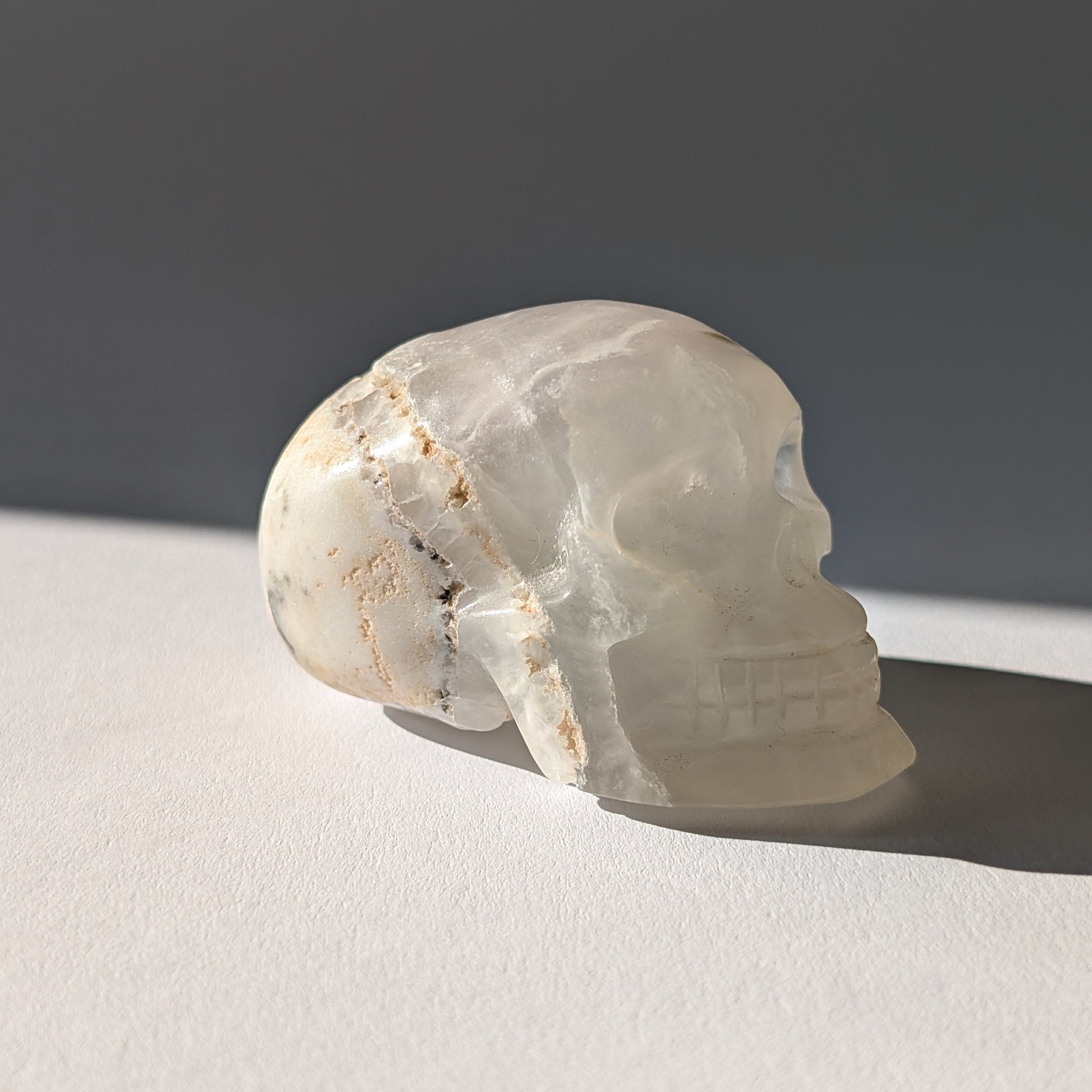 Kristallschädel "Baranor" (152g) aus Quarz mit dunklen dendritischen Einschlüssen (Baum-Achat Optik).