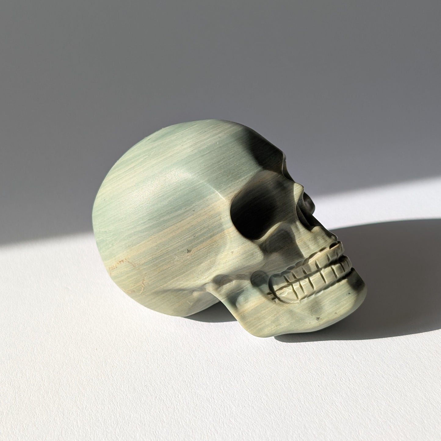 Kristallschädel "Brynjolf" (204g) aus sanft grün gebändertem Ozean Jaspis.