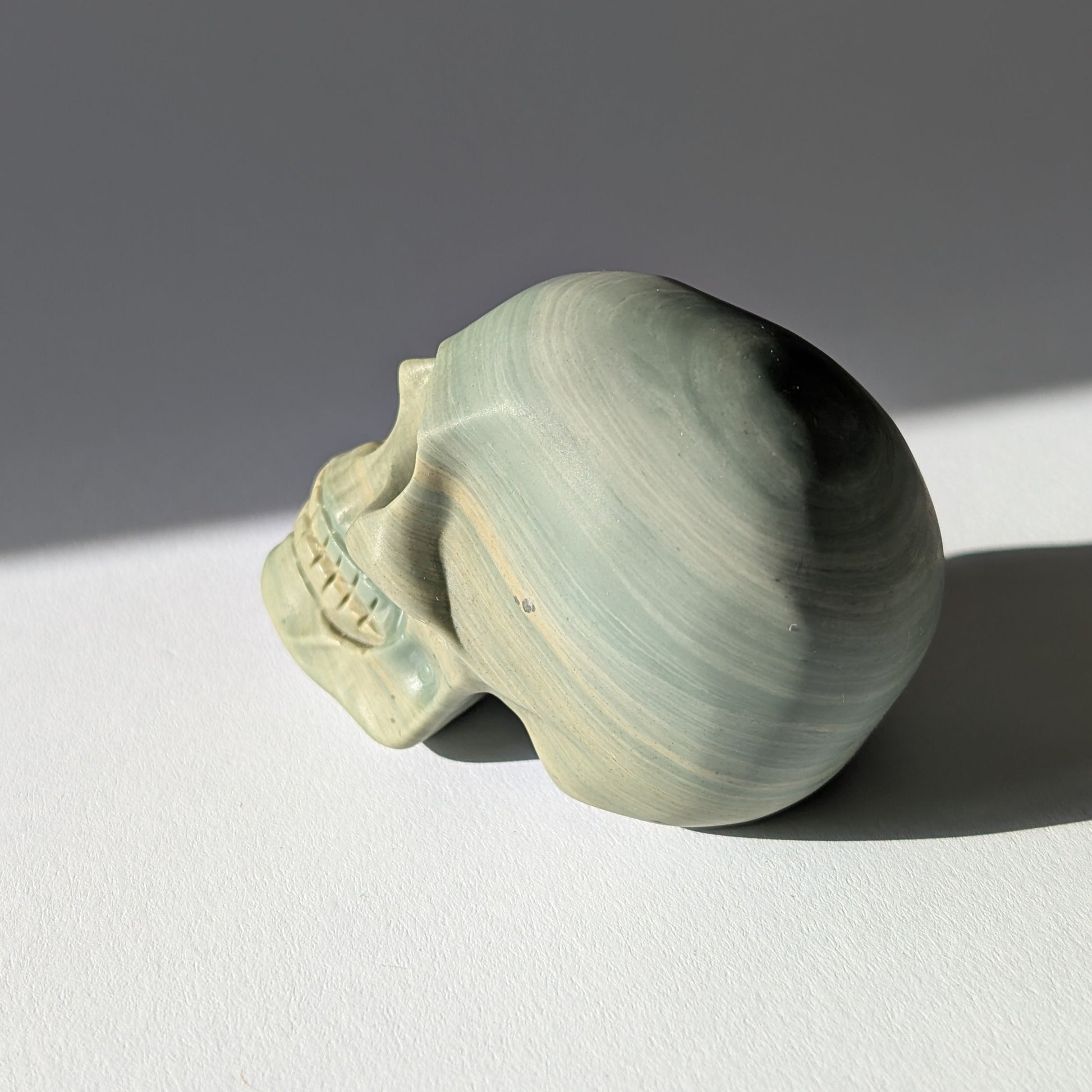 Kristallschädel "Brynjolf" (204g) aus sanft grün gebändertem Ozean Jaspis.