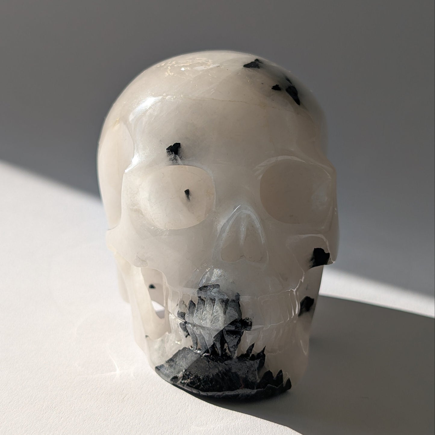 Kristallschädel "Cornelius" (645g) aus Quarz mit vielen schwarzen Turmalin-Nadeln.