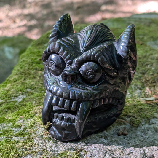 Kristallschädel "Dämonenwächter" aus tiefschwarzem Obsidian in Form einer mythischen Kreatur.